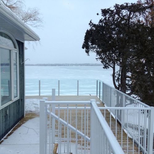 Waterfront home with a combo glass and picket railiing in white