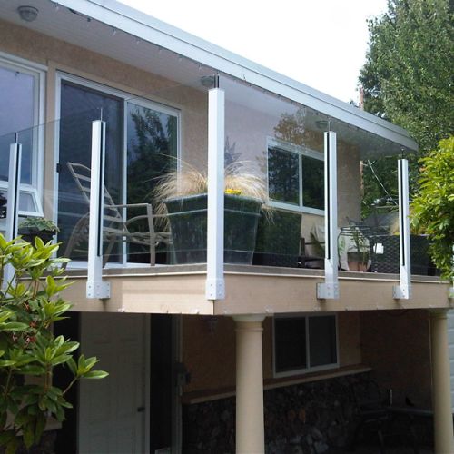 White fascia mount aluminum railing posts with tempered glass panels