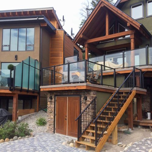 Wood home with black picket stair railing combined with glass railing with black top and bottom railing