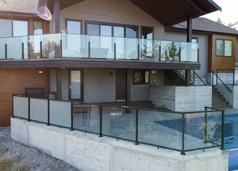 Home w/ DekSmart glass railing kit around the pool, the balcony, and stairs.