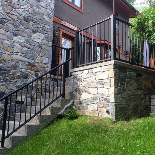 Outdoor stairs with black picket handrail and deck railing