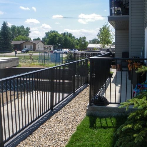 Black picket railings in a house backyard