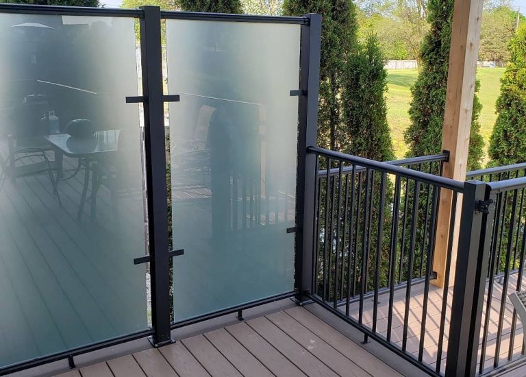 DekSmart Railings glass privacy wall and picket railing with frosted glass.