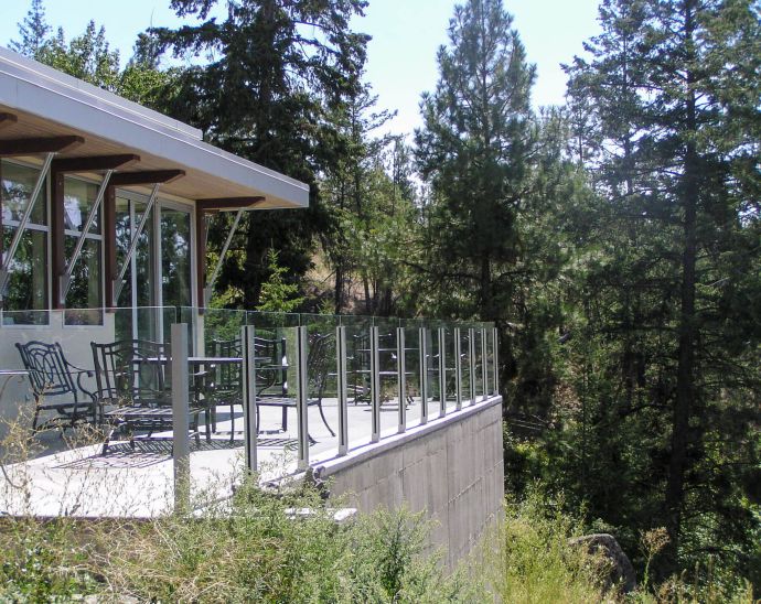 Topless short height glass railing in a house back yard patio.