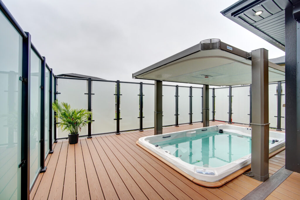 Hot tub with tall privacy glass and wind screen by DekSmart at 4 Crownridge Drive