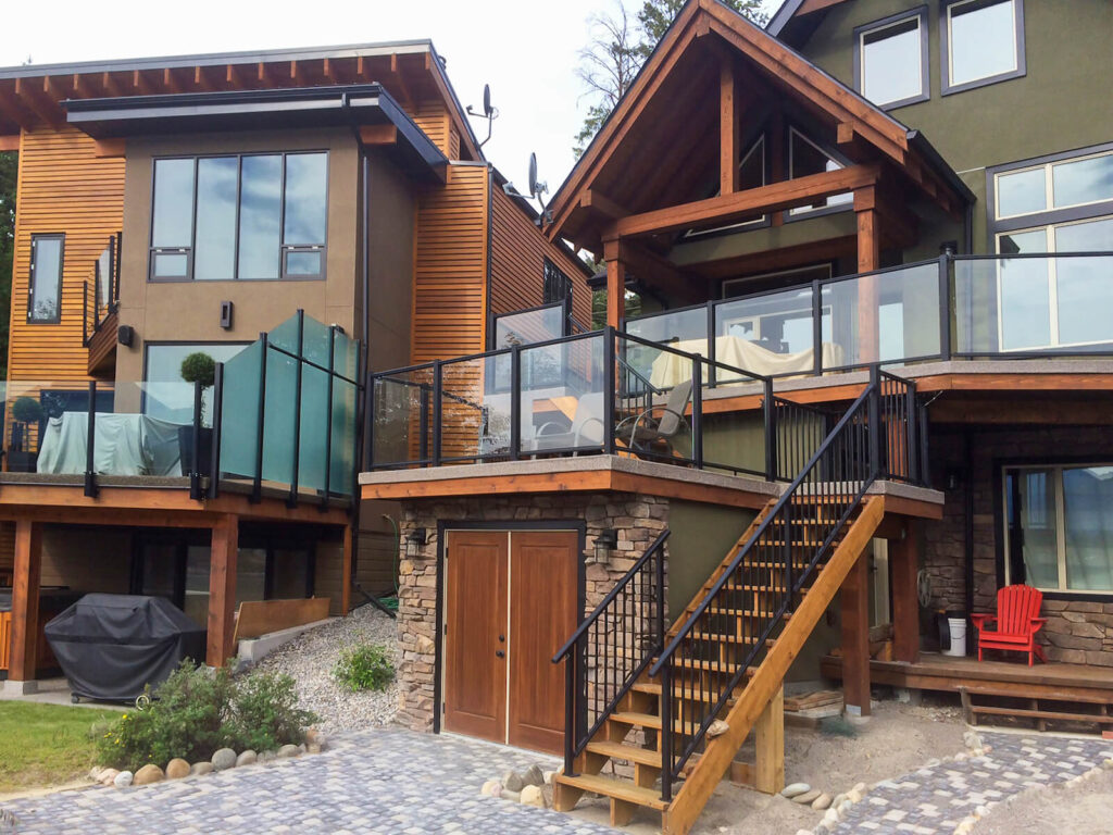 Wood home with black picket stair railing combined with glass railing with black top and bottom railing